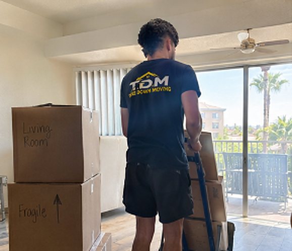 T.D.M mover with a dolly stacked with boxes in an apartment