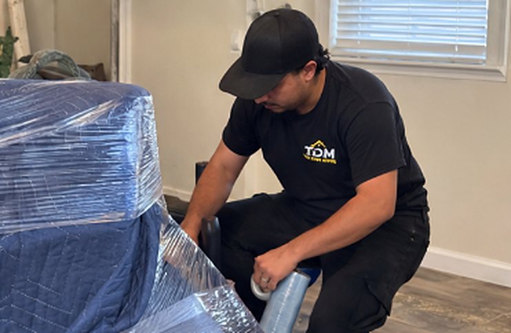 T.D.M mover shrink-wrapping furniture to protect it